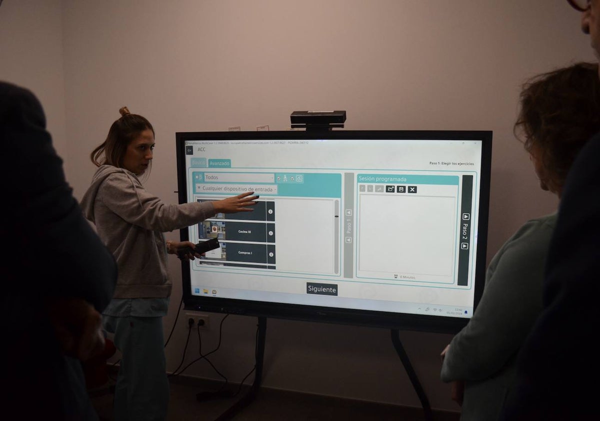 Imagen principal - Explicación guiada por el CAIT; entrega de un ramo de flores a Catalina García y uno de las nuevas tablets para trabajar con los usuarios.