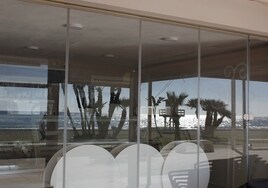 El paseo marítimo de Rincón de la Victoria, reflejado en el ventanal de uno de los negocios allí ubicados.