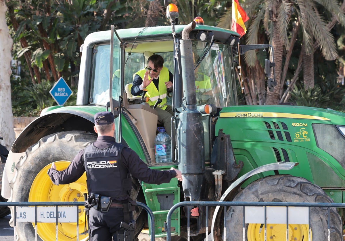 Una gente de la Policía Nacional dialoga con un agricultor, este martes, en Málaga.