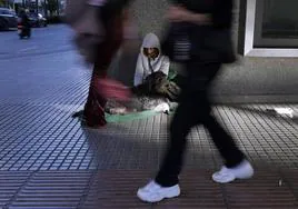 Ana, con su perra Luna, ante el pasear de los viandantes.