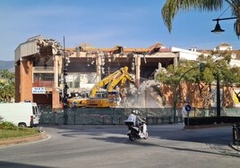 Una moto circula delante del edificio de Mercacentro, que se encuentra en fase de demolición.