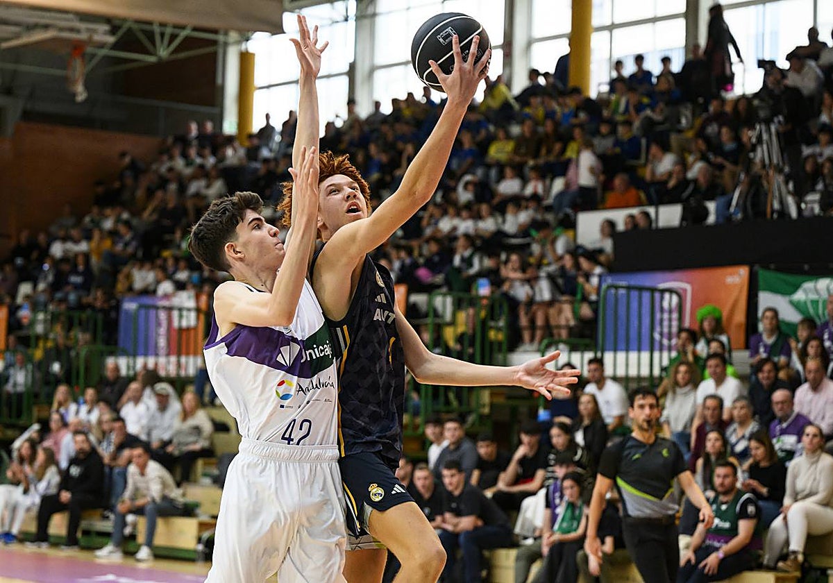 Martínez intenta evitar la canasta de un jugador del Madrid.
