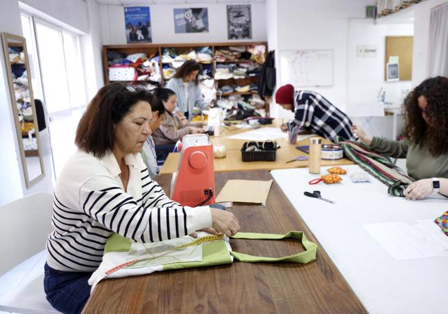 En primer plano, Aurora Gallardo, que aprende a coser y también hace las veces de comercial del taller: consigue donaciones de material de empresas textiles.