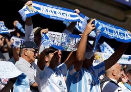 Aficionados del Málaga muestran sus bufandas blanquiazules en la grada de La Rosaleda durante el último partido en casa contra el Recreativo de Huelva.