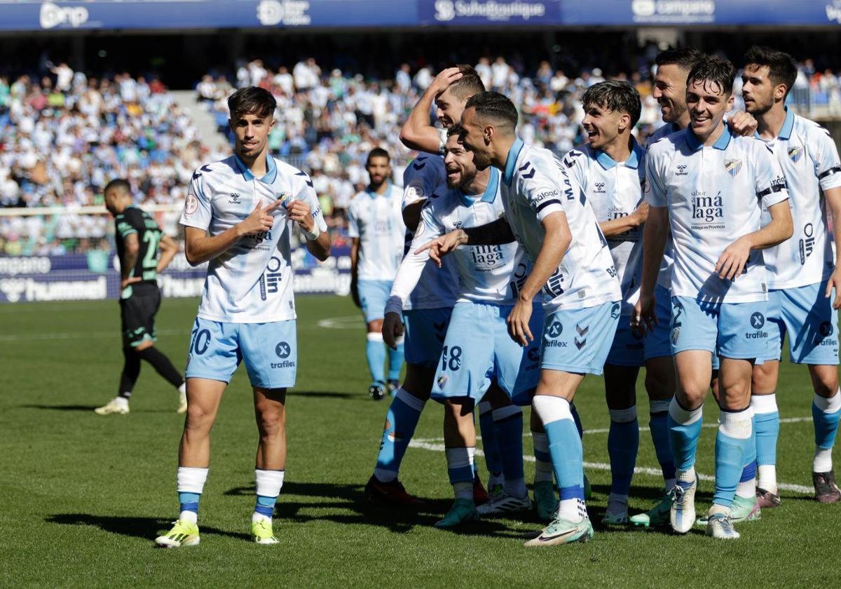 El futbolista del Málaga David Larrubia, a la izquierda de la imagen, celebra su participación en el gol en propia meta del rival que puso el 3-0 definitivo contra el Atlético Baleares en La Rosaleda.