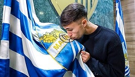 David Larrubia besa el escudo del Málaga en la presentación oficial de su renovación con el club hasta 2027.