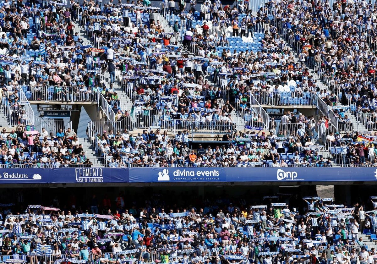 Aficionados del Málaga apoyan a su equipo en La Rosaleda contra el Recreativo.