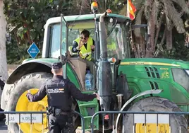 Un agente de la Policía Nacional discute con un agricultor, en las protestas del sector en Málaga capital.