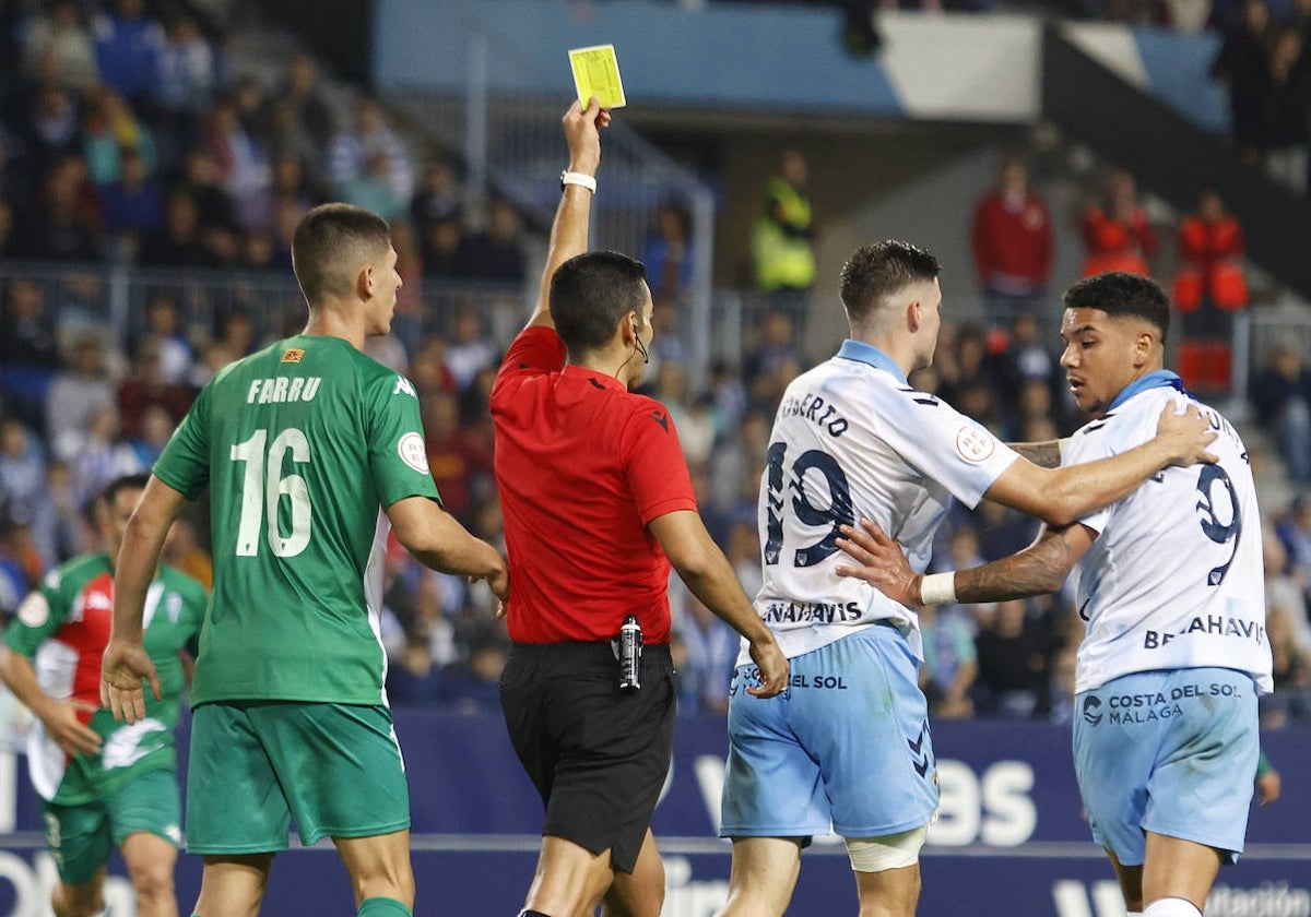 El árbitro muestra una tarjeta amarilla a Loren Zúñiga ante el Alcoyano.