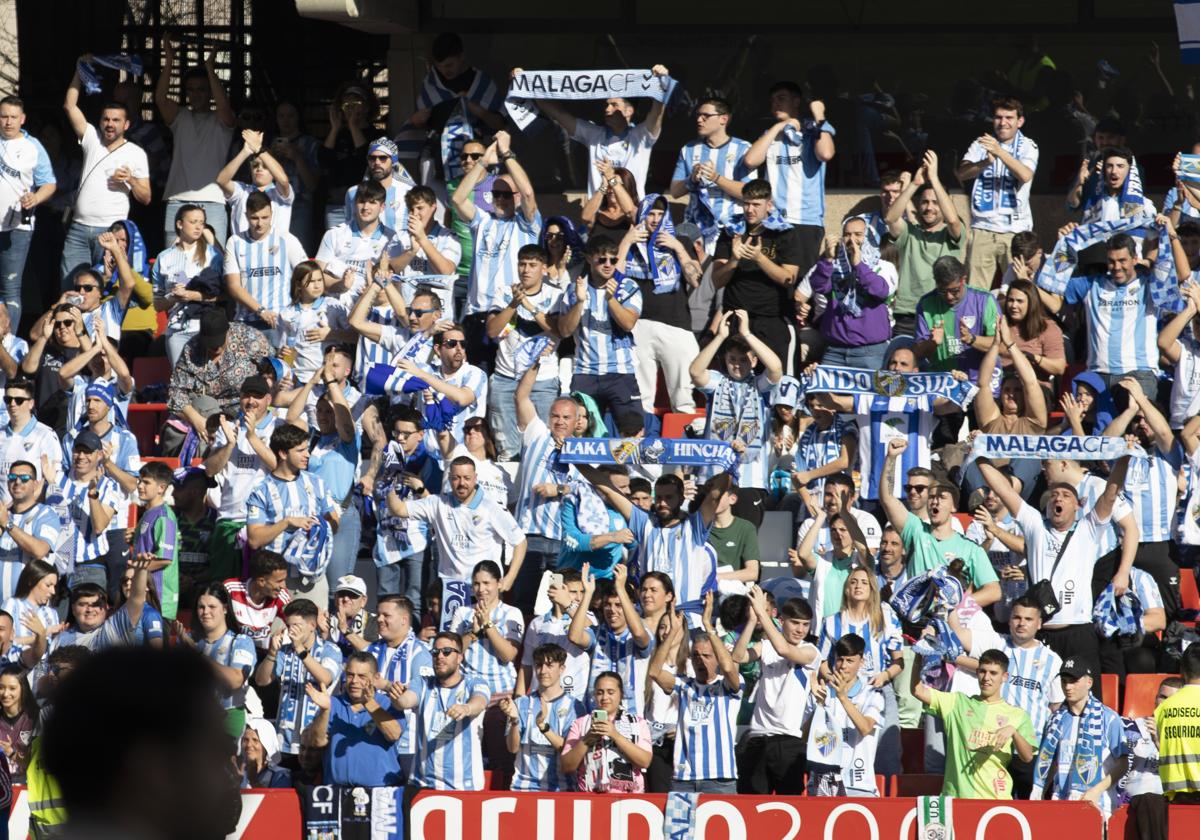 Fotografía de aficionados del Málaga en las gradas del estadio Nuevo Los Cármenes en el desplazamiento masivo de más de 5.000 seguidores blanquiazules para el partido contra el Recreativo Granada esta temporada.