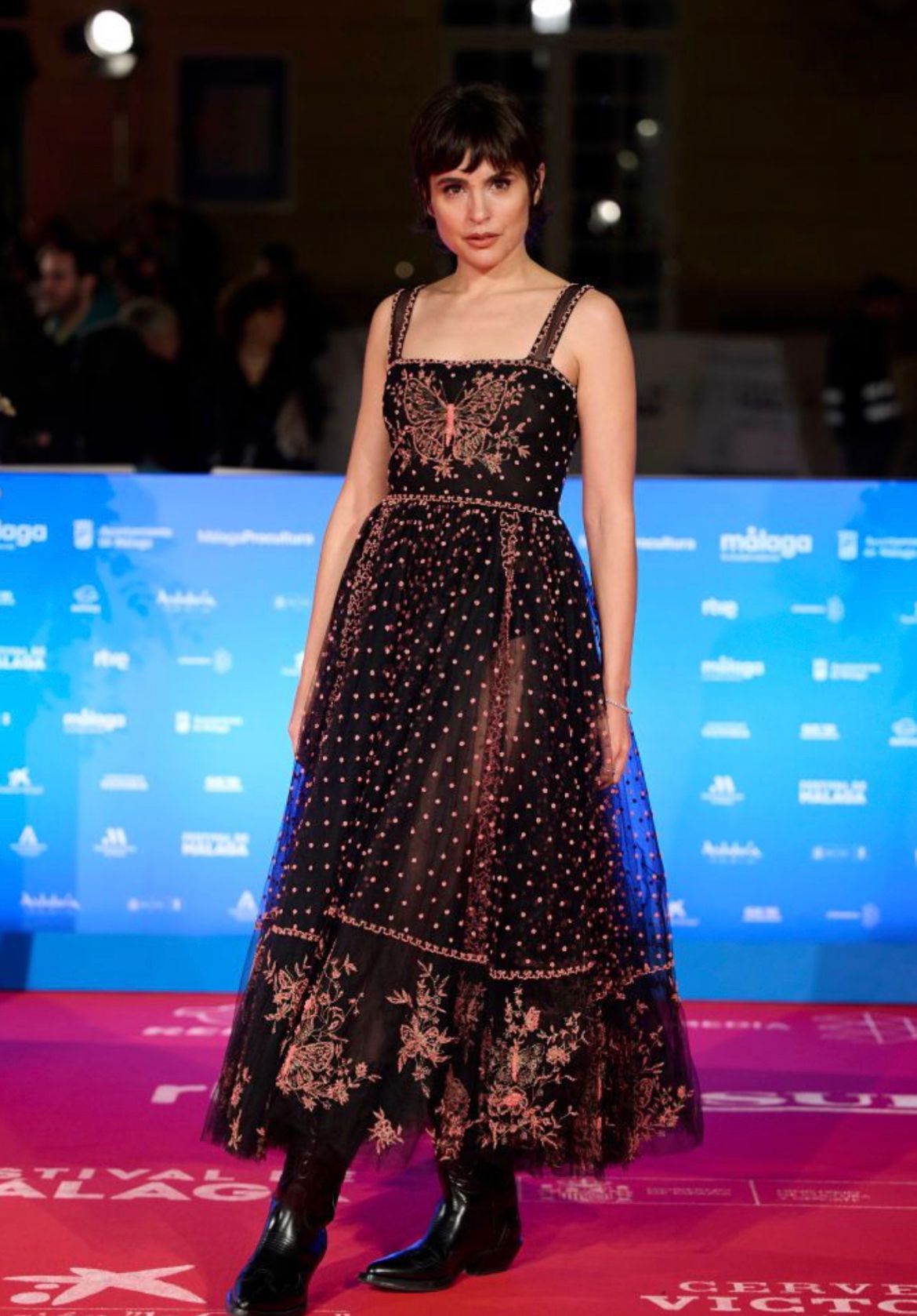 La actriz, que acudía a la presentación de la película 'Yo no soy esa', deslumbró con un impresionante vestido de Christian Dior de la colección Crucero 2024. Un diseño de estilo boho con escote cuadrado y románticos detalles bordados en rosa que combinó con unas espectaculares botas de estilo 'cowboy', también de Dior, en piel negra y con el logo dorado en el lateral. Impecable.