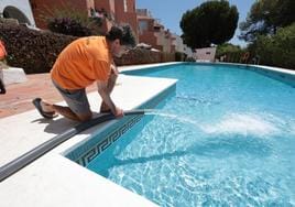 Un empleado controla el llenado desde un camión cuba de una piscina, en una imagen de archivo.