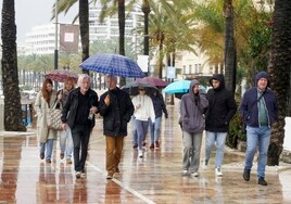 Los turistas paseaban ayer con paraguas por el litoral y el centro de Marbella.