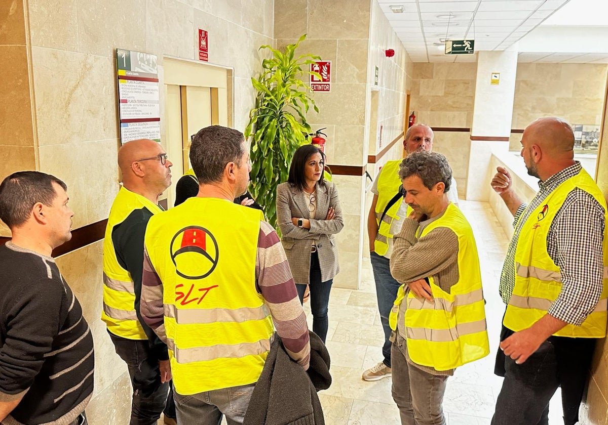 La viceportavoz del Grupo Municipal Socialista, Trini Gómez, charla con los trabajadores del servicio de autobús.