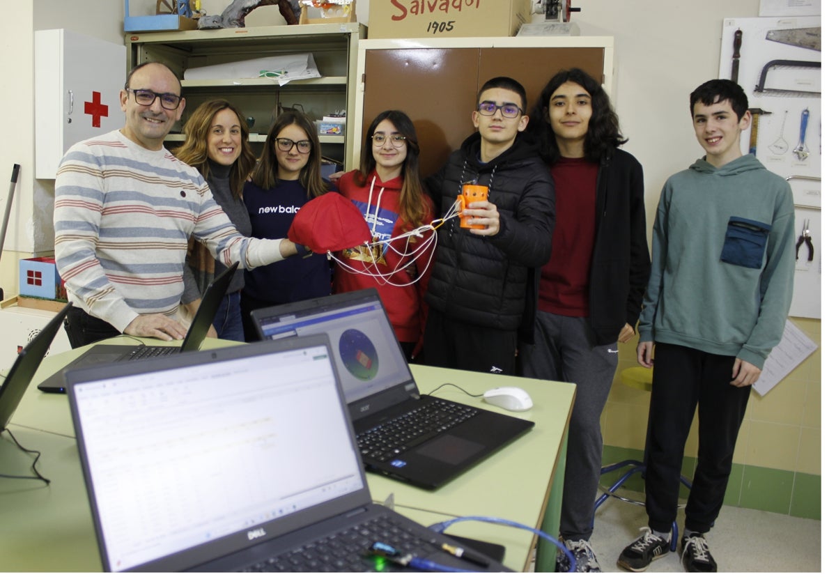 Imagen principal - En la imagen superior, Alfonso Lobato, Ana Isabel Moscoso, Kiara Rodríguez, María Rivas, Samuel Díaz, Álvaro González-Posada y Sergio Larrubia posan con el satélite; en el centro, primer plano del paracaídas, tan importante como el resto del dispositivo, ya que permite su recuperación. Sobre estas líneas, el aparato, en forma de lata, lleno de sensores.