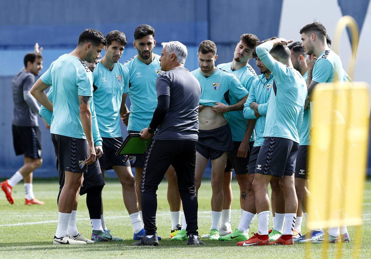 Jugadores del Málaga atienden las indicaciones del técnico Pellicer en un entrenamiento de esta semana.