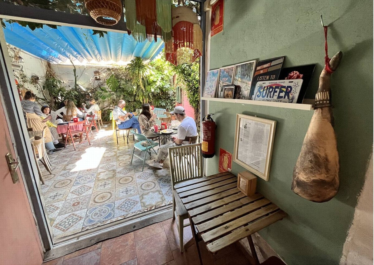 Imagen secundaria 1 - Arriba, salón principal del establecimiento de la calle San Pancracio, con el piano al fondo. Abajo, entrada al patio y detalle del interior.