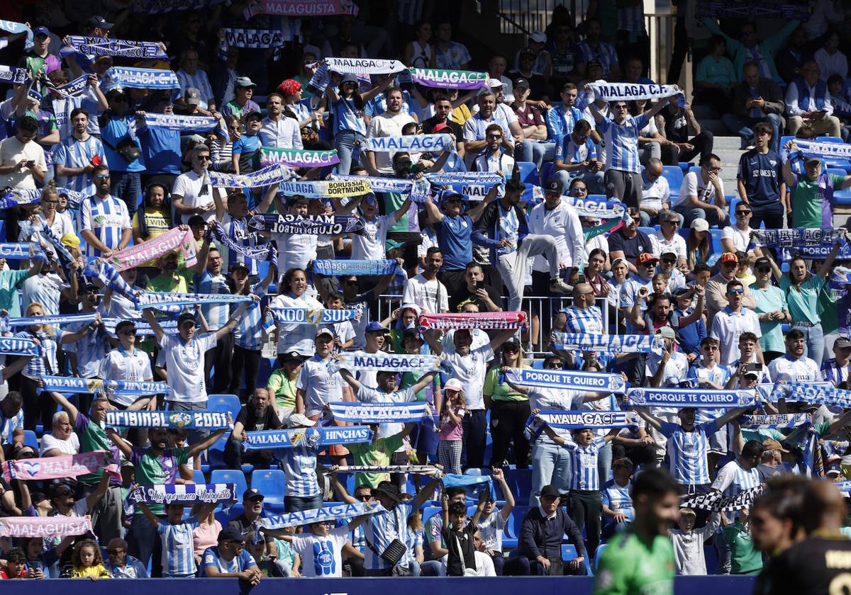 Imagen de aficionados del Málaga animando durante un partido de esta temporada en La Rosaleda.