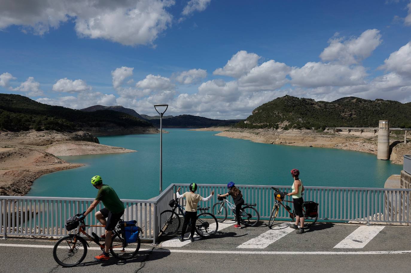 Una familia disfruta de las vistas del embalse, con el agua turquesa.