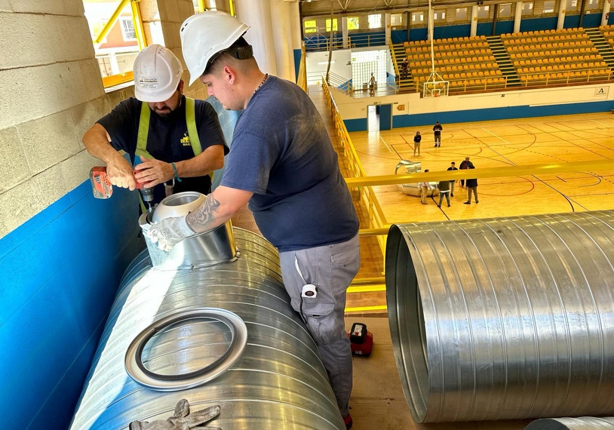 Operarios trabajan en las labores de climatización de las instalaciones deportivas.