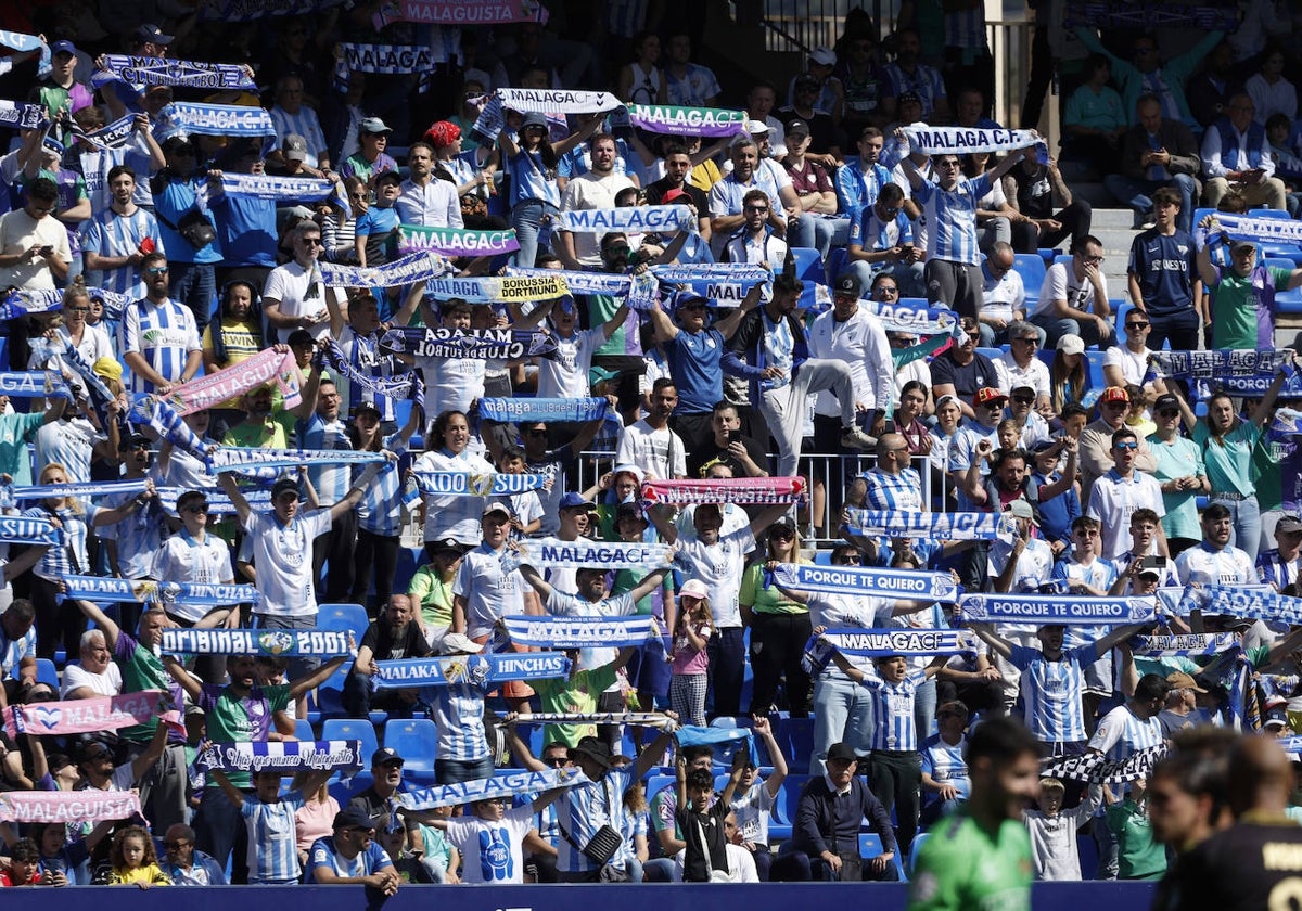 Aficionados del Málaga animan a su equipo en La Rosaleda.