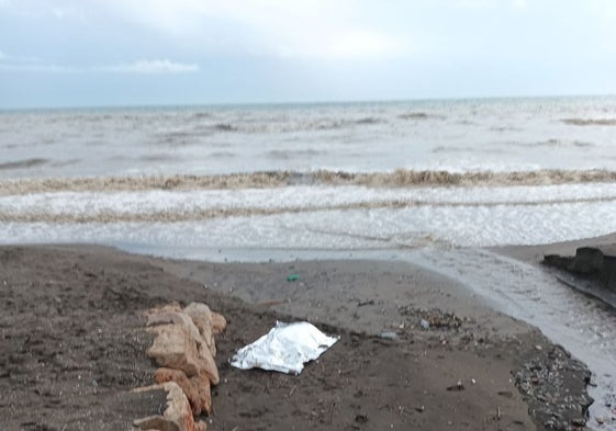 Imagen del cadáver de la mujer, tapado con una sábana, en la orilla de la playa de El Morche, el pasado Sábado Santo.