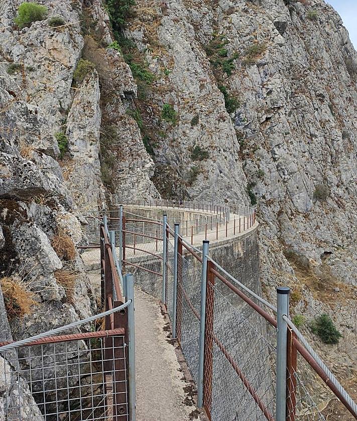 Imagen secundaria 2 - Las dimensiones de su entrada impresionan. Abajo, sólo se puede avanzar unos metros en su entrada. Y el camino vertiginoso de la presa de los Caballeros.