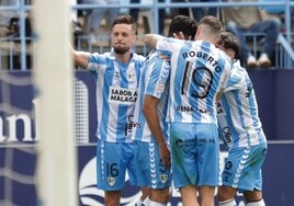 Los jugadores del Málaga celebran el gol marcado en el partido frente al Ceuta, el único que jugaron con la camiseta conmemorativa, adaptada para cumplir los acuerdos comerciales (la de venta al público lleva la publicidad de Tivoli).