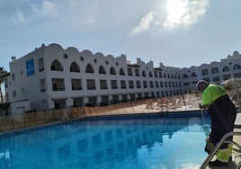 Un operario del Ayuntamiento de Benalmádena recoge el agua de la piscina de un hotel, donada para el riego.