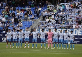 El once inicial del Málaga, durante el minuto de silencio en el encuentro del domingo en La Rosaleda.