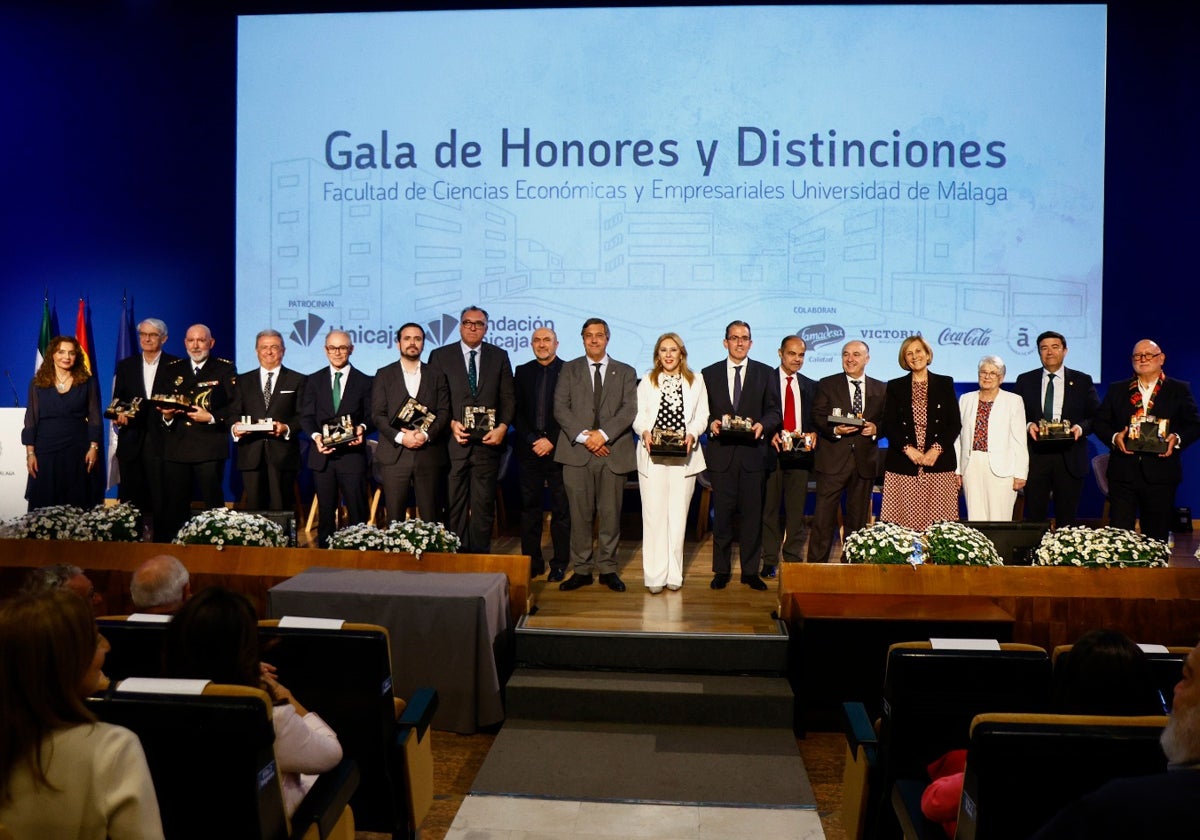 El rector, Teo López, y el decano, Eugenio Luque, con los antiguos estudiantes reconocidos con las insignias y nombrados alumnos de honor.