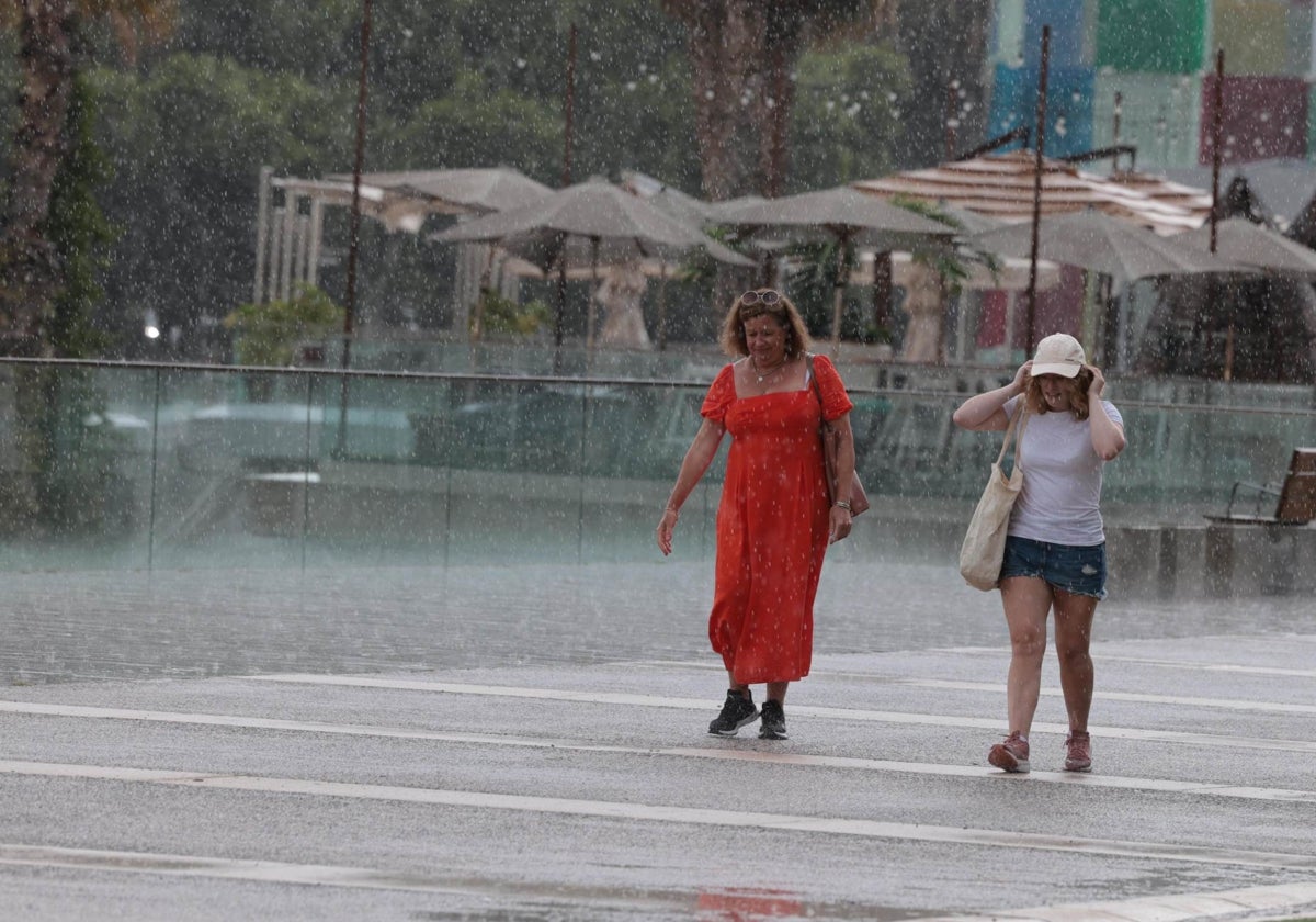 Turistas sorprendidas por los aguaceros de esta semana en el Muelle Uno de Málaga.