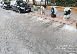 Manchas en la calzada junto a los contenedores, en la calle La Fuensanta de Fuengirola.