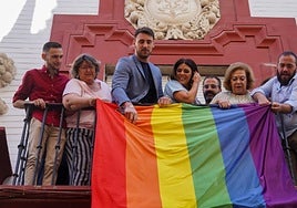 El responsable de políticas Lgtbi del PSOE-A, Manolo Rosado, a la derecha colocando la bandera de este colectivo en la sede socialista de Sevilla.