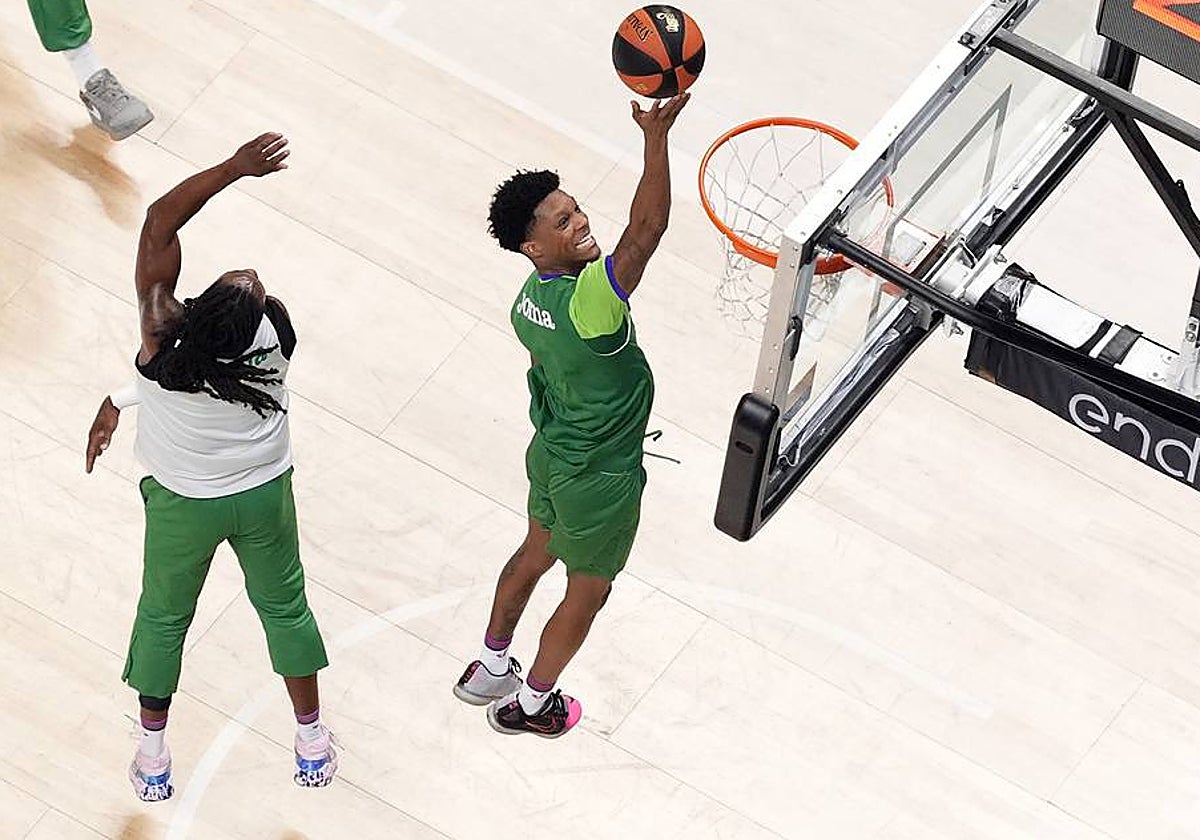 Carter se escapa de la defensa de Perry para anotar una bandeja mientras sonríe.