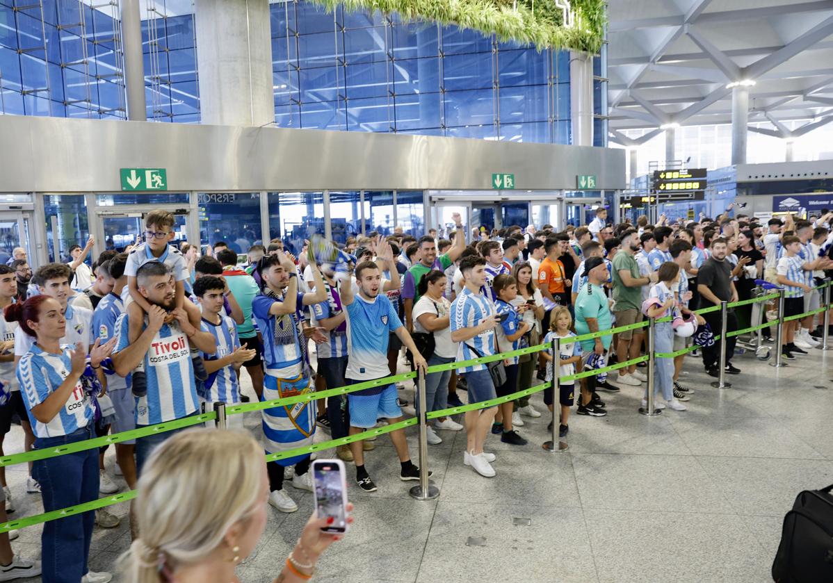 Imagen principal - Cientos de aficionados emocionan al Málaga en el aeropuerto antes de viajar a Vigo