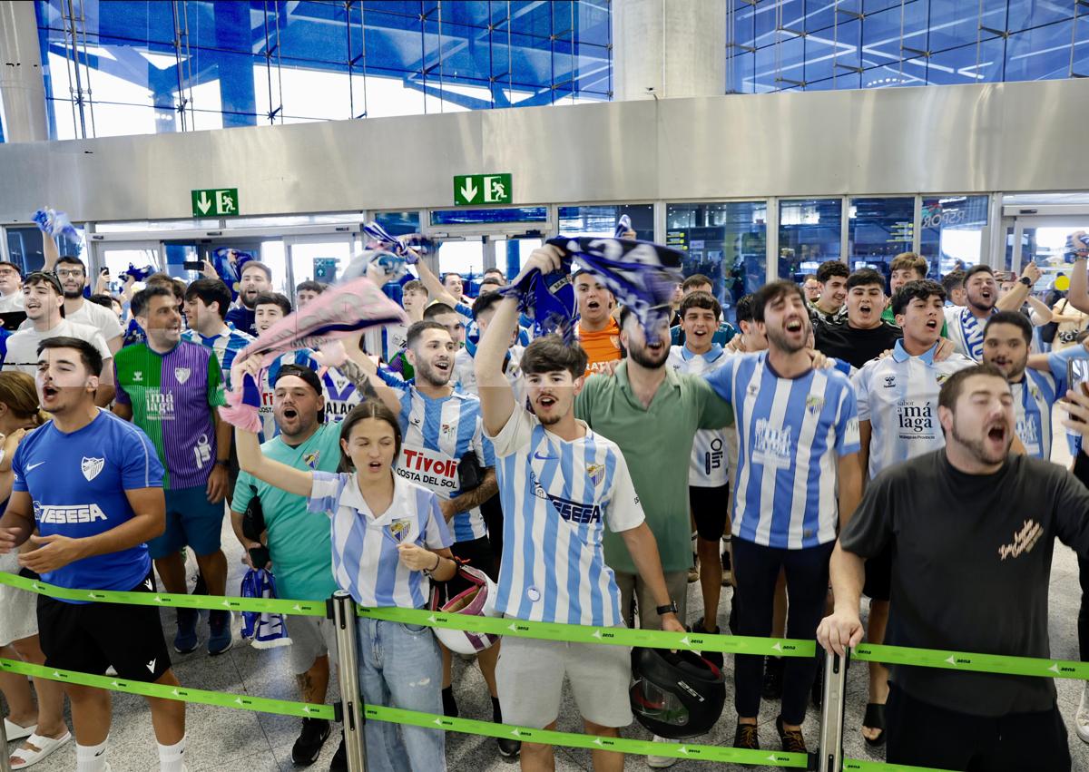 Imagen secundaria 1 - Cientos de aficionados emocionan al Málaga en el aeropuerto antes de viajar a Vigo