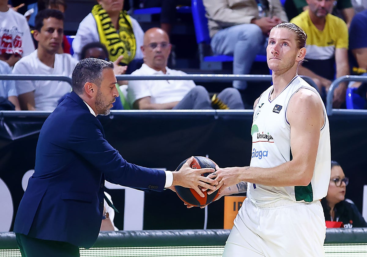 Ibon Navarro entrega a Osetkowski el balón durante un partido.