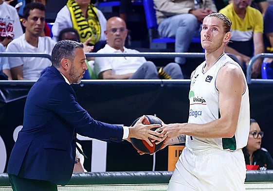 Ibon Navarro entrega a Osetkowski el balón durante un partido.