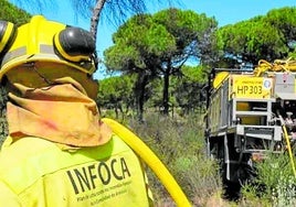 Un efectivo del Plan Infoca con uno de los vehículos autobomba que forman parte del dispositivo.