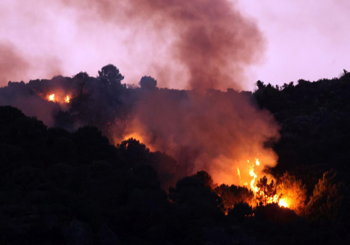 Imagen principal - Tras un día de trabajo intenso, el Infoca da por controlado el incendio de Casares
