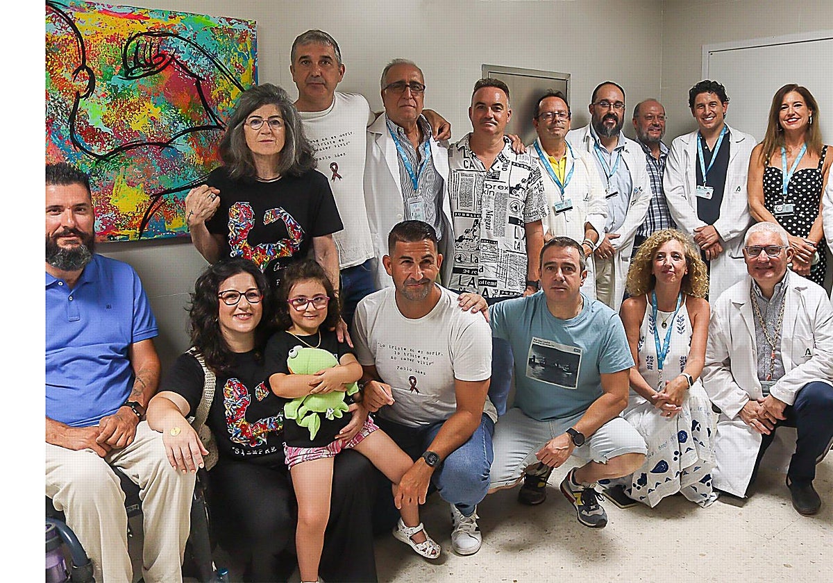 Profesionales sanitarios y familiares de Pablo Ráez posan con el cuadro inspirado en el joven marbellí.