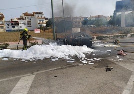 Bomberos sofocando las llamas, este lunes en Torre del Mar.