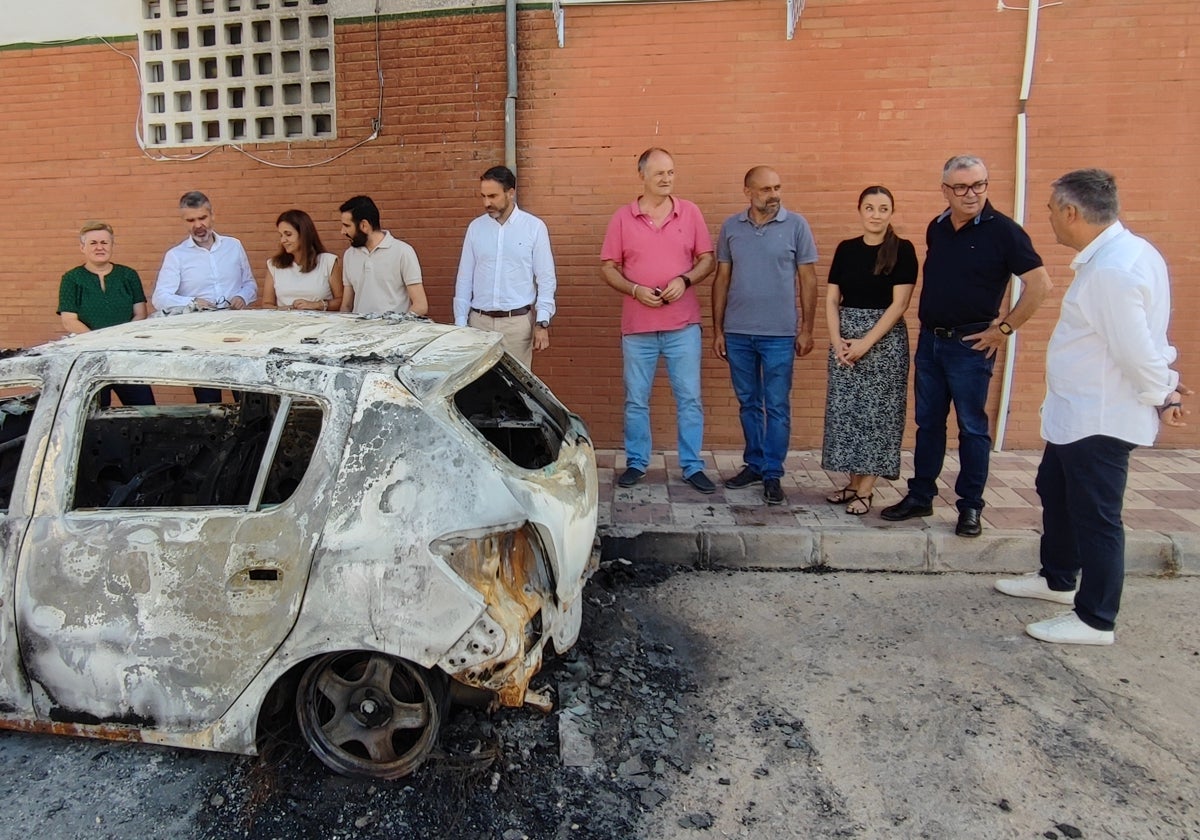 Ediles, alcaldes y dirigentes socialistas, este miércoles en Periana junto al coche incendiado.