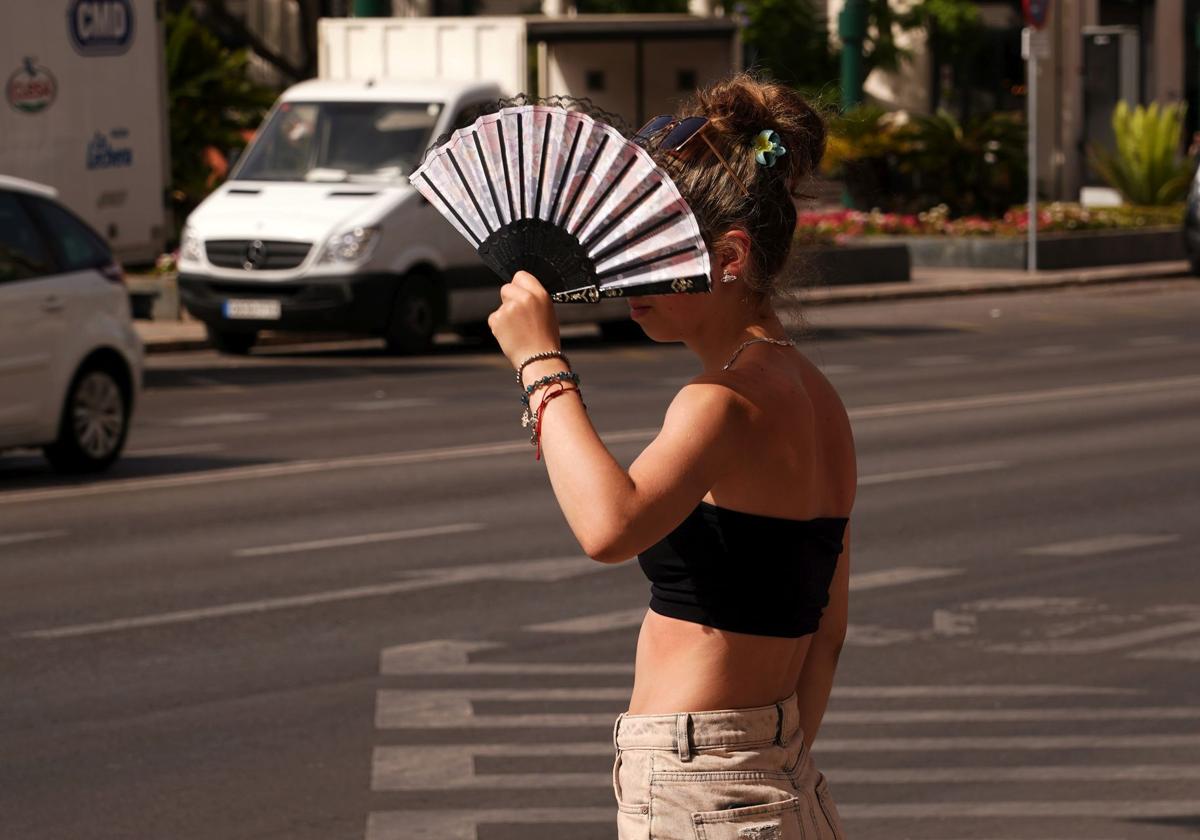 Una joven se protege del sol, ayer en Málaga