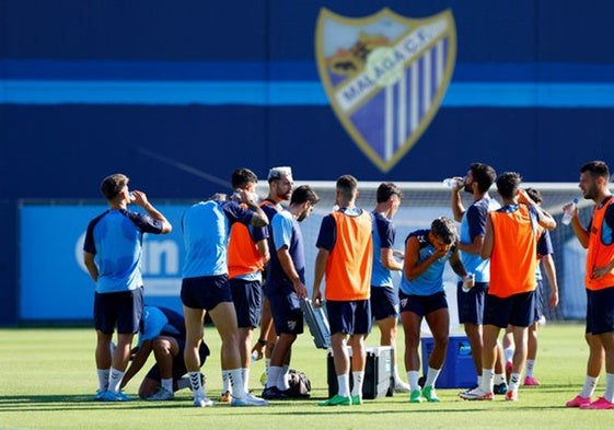 Los jugadores del Málaga se hidratan en el entrenamiento de este jueves en La Rosaleda.