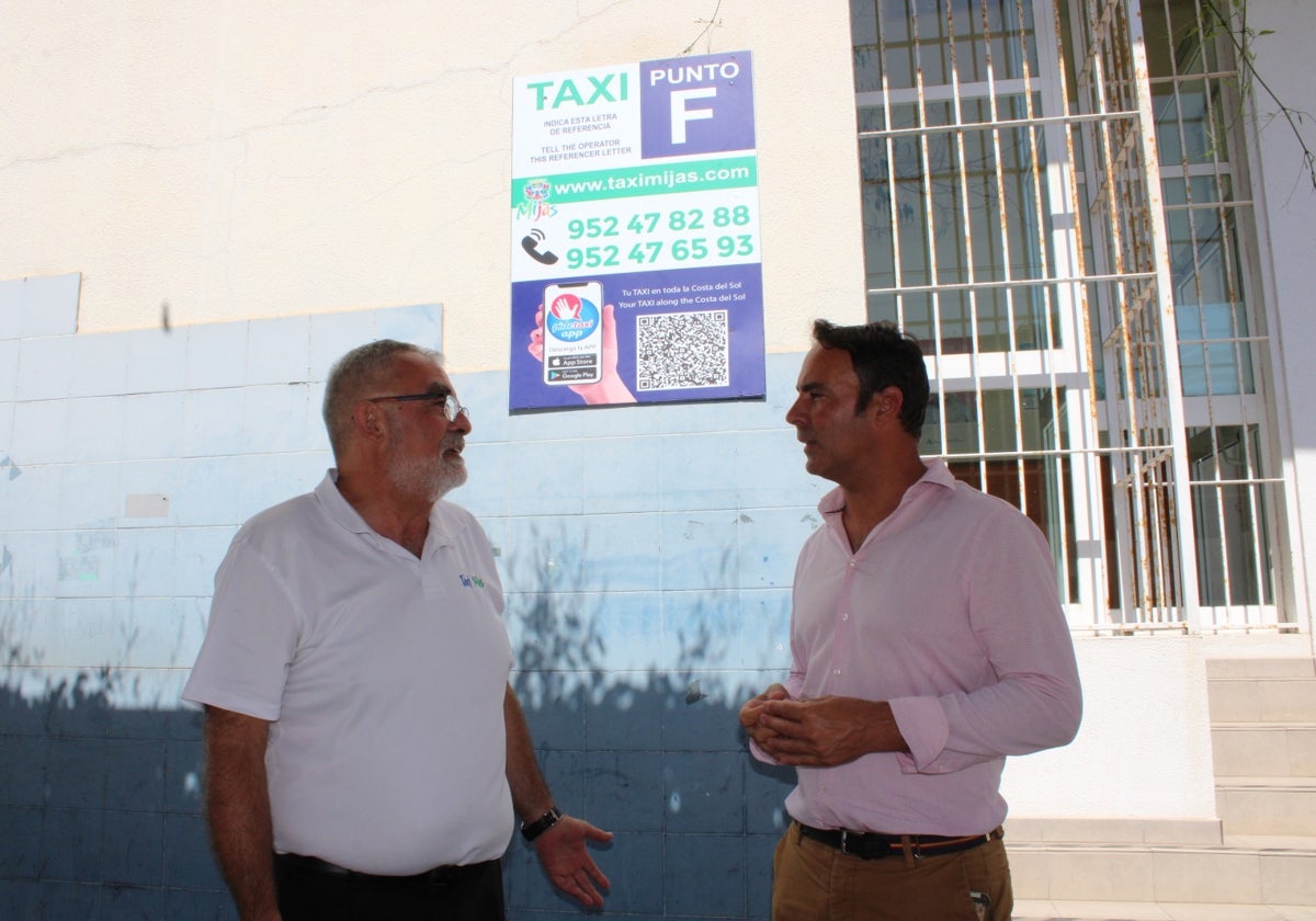 El concejal y el presidente de Radio Taxi Mijas delante de uno de los paneles instalados en el municipio.