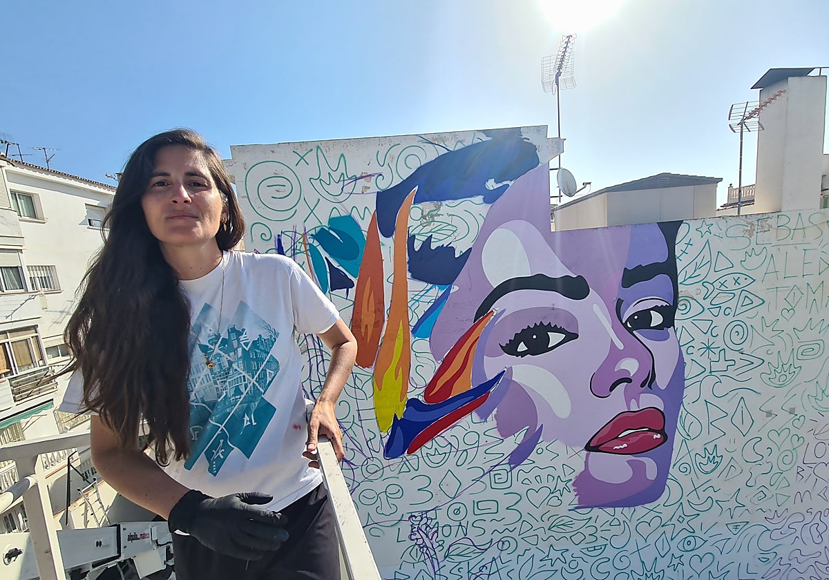 Ana Cortés 'Bosska', en la grúa, con el mural que pinta El Calvario.
