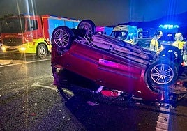 Imagen del accidente con el turismo volcado.