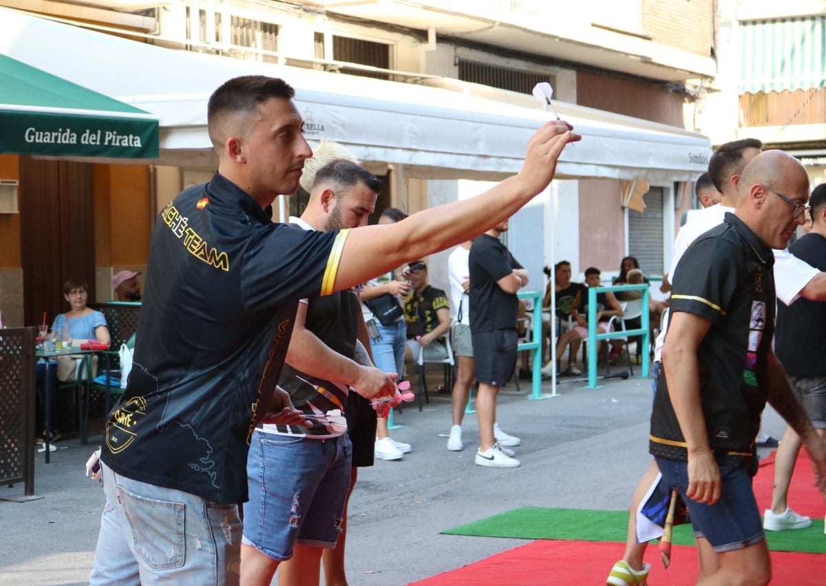 Imagen secundaria 1 - Jugadores durante la celebración de la tercera edición del torneo del Club de Dardos de Pizarra en la primera imagen; Riky Pérez en la segunda, y una de las dianas del torneo en la tercera.